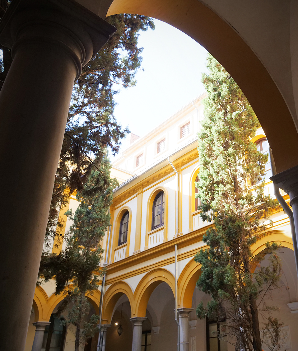 Los rayos de sol alcanzan la planta superior de la Facultad de Derecho, mientras que su patio, columnas y pasillos permanecen a la sombra